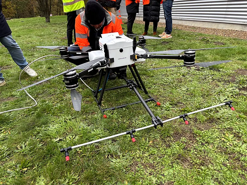 Reinigingsdrone met sproeibalk op het gras